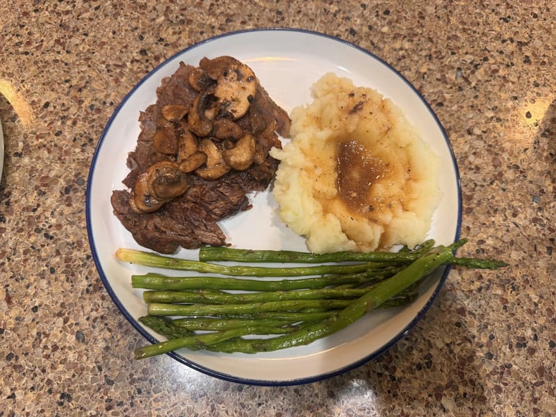 An evening plate: steak with mushroom gravy, mashed potatoes, and asparagus