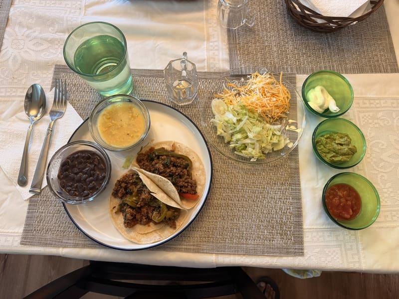 Home-cooked tacos plated with black beans and fresh sides